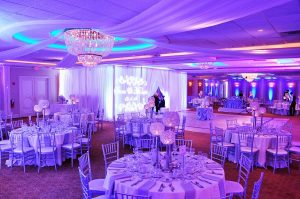 Luxurious quinceañera at Astoria Banquet Hall with decorated tables and centerpieces.