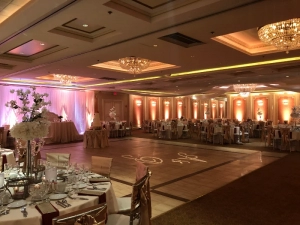 Elegant quinceañera celebration at Astoria Banquets with decorated ballroom and grand chandelier. Elegante celebración de quinceañera en Astoria Banquets con salón de baile decorado y gran candelabro